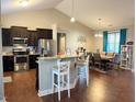Modern kitchen featuring stainless steel appliances, dark wood cabinetry, and breakfast bar seating at 108 Kaspurr Dr, Garner, NC 27529