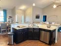 Kitchen island with granite countertops and stainless steel sink overlooking living and dining areas at 108 Kaspurr Dr, Garner, NC 27529