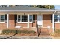 Inviting brick front porch with white columns and black shutters, showcasing the home's address above the door at 205 N Augusta Ave, Benson, NC 27504