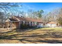 Side view of brick home showcasing a large yard and detached structures at 2540 Mayo Lake Rd, Roxboro, NC 27574