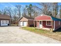 View of detached garage and red shed with spacious parking area at 2540 Mayo Lake Rd, Roxboro, NC 27574