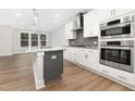 Bright, white kitchen features a gray kitchen island and stainless steel appliances at 316 Church St, Morrisville, NC 27560