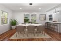 Bright dining area with hardwood floors, large windows, stylish light fixture, and bar seating at 3907 Inwood Dr, Durham, NC 27705