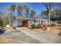 Brick ranch home with carport, mature trees, and a stone accent at 5317 Ten Ten Rd, Apex, NC 27539