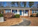 Charming brick house with a blue door and manicured landscaping at 5317 Ten Ten Rd, Apex, NC 27539