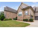 Multi-level home with stone and siding exterior, showcasing a three-car garage at 7440 Bleasdale Ct, Apex, NC 27539