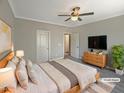 Virtually staged bedroom with large bed, dresser, and TV at 902 Laurel Gate Dr, Wake Forest, NC 27587