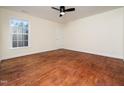 This bright, spacious bedroom features hardwood floors, a large window, ceiling fan, and neutral walls at 9412 Harvest Acres Ct, Raleigh, NC 27617