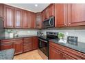 Kitchen features dark wood cabinets, granite countertops, stainless steel appliances, and tile backsplash at 9412 Harvest Acres Ct, Raleigh, NC 27617