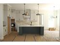 Modern kitchen with island, quartz countertops, neutral backsplash, and pendant lighting at 1021 Smoke Willow Way # 130, Rolesville, NC 27571