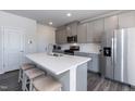 Modern kitchen with gray cabinets, white countertop island, and stainless steel appliances at 1388 Fruit Cobbler Dr, Haw River, NC 27258