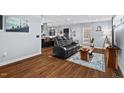 Open-concept living room featuring hardwood floors, a modern leather sofa, and a view into the kitchen at 1801 Liberty St, Durham, NC 27703