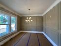 Sunlit living room with decorative trim, large window, and contemporary chandelier at 190 Broadleaf Ln, Louisburg, NC 27549