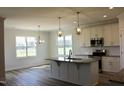 Open kitchen with granite countertops, stainless steel appliances, and decorative lighting at 24 Surles Landing Way, Benson, NC 27504