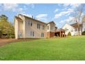 Large backyard with green grass and the home's beige siding, showcasing the outdoor space and potential for landscaping at 306 Neuse Ridge Dr, Clayton, NC 27527