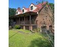 Brick home with long wrap-around porch and red metal roof at 515 Docs Rd, Lillington, NC 27546