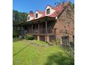 Brick home with long wrap-around porch and red metal roof at 515 Docs Rd, Lillington, NC 27546