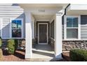 Front entrance with stone accents and a dark brown door at 5940 Illuminate Ave, Raleigh, NC 27616