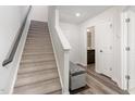 Carpeted staircase with a gray bench at the landing at 5940 Illuminate Ave, Raleigh, NC 27616