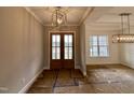 Spacious foyer featuring elegant lighting fixtures and large double doors, creating a grand entrance at 90 Firefly Ln, Louisburg, NC 27549