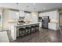 Open kitchen featuring white cabinets, granite counters, and an island with seating at 1008 Country Pasture Cv, Wendell, NC 27591