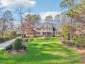 Large brick house with driveway and green lawn, near golf course at 302 Champions Point Way, Cary, NC 27513