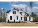 Stunning modern farmhouse with white siding, black windows, and a welcoming front porch at 3912 Cedar Knolls Dr, Youngsville, NC 27596