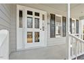 White front door with glass panes and black shutters, leading to a cozy front porch at 101 Stefi Ct, Garner, NC 27529