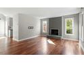 Bright living room featuring hardwood floors, a fireplace, and large windows at 101 Stefi Ct, Garner, NC 27529