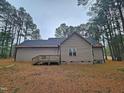 Rear view of the house with deck and wooded backdrop at 117 Majestic Dr, Princeton, NC 27569