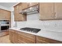 Modern kitchen showcases white countertops, designer backsplash and stainless steel appliances at 200 Regency Ridge Dr, Holly Springs, NC 27540