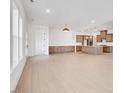 Spacious living room with an open floor plan and hardwood floors leading to the kitchen at 200 Regency Ridge Dr, Holly Springs, NC 27540