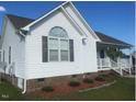 Side view of a single story home with white siding and brick base at 288 Rosa Cir, Willow Springs, NC 27592