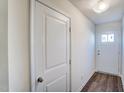 A hallway featuring wood floors, white trim, and a white front door with glass inserts at 851 Parc Townes Dr # 10, Wendell, NC 27591