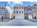 Three-story townhome with gray siding, a two-car garage, and a modern exterior design in a suburban setting at 861 Parc Townes Dr # 6, Wendell, NC 27591