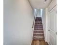 Carpeted staircase with a wooden handrail, bright natural light and a neutral color scheme, ready for your personal touch at 861 Parc Townes Dr # 6, Wendell, NC 27591