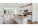 Bright kitchen features a granite island, stainless appliances, white cabinets, and hardwood floors for seamless entertaining at 867 Parc Townes Dr # 3, Wendell, NC 27591