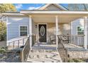 Inviting front porch with black railing and stone steps at 1004 N Fayetteville Ave, Dunn, NC 28334