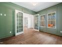 Home office with green walls, hardwood floors, and French doors at 126 Sanderway Dr, Chapel Hill, NC 27516