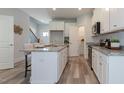 Bright kitchen featuring an island, white cabinets, and granite countertops at 1741 Old Fields Blvd, Haw River, NC 27258