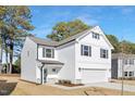 Angle view of a home showcasing white siding, gray shutters, and a spacious two-car garage at 216 Horseshoe Pl # 25, Angier, NC 27501