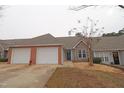 Condo exterior featuring two-car garage and landscaping at 2530 Friedland Pl # 104, Raleigh, NC 27617