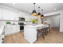 Spacious kitchen with white cabinets, island, and modern lighting fixtures at 35 Mable Court # 3, Lillington, NC 27546