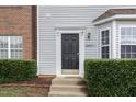 Attractive front entry of townhome with black door and neatly landscaped area at 10947 Pendragon Pl, Raleigh, NC 27614