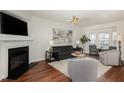 Bright living room with hardwood floors, fireplace, and comfortable seating area at 10947 Pendragon Pl, Raleigh, NC 27614