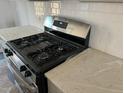 Stainless steel gas cooktop and quartz countertops in a modern kitchen at 1235 Willow Tree Way, Graham, NC 27253