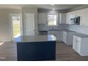 Modern kitchen with white cabinets, granite countertops, and a large island at 19 Shiloh Dr, Lillington, NC 27546
