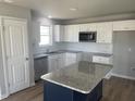 Modern kitchen featuring white cabinets, granite countertops, and an island at 19 Shiloh Dr, Lillington, NC 27546