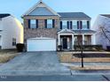 Two-story brick home with gray siding, two-car garage, and landscaping at 302 Glenview Ln, Durham, NC 27703