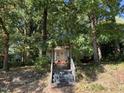 Yellow cottage with stairs leading up to the front door, surrounded by trees at 322 Mccauley St, Chapel Hill, NC 27516